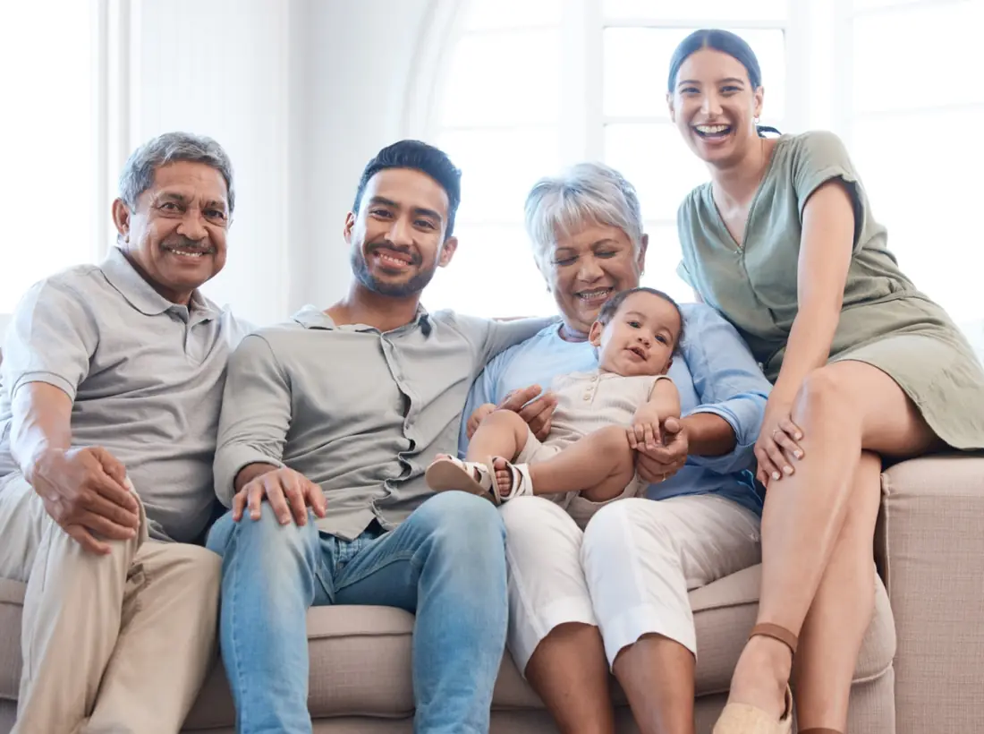 Four generations of one family sitting together on a sofa